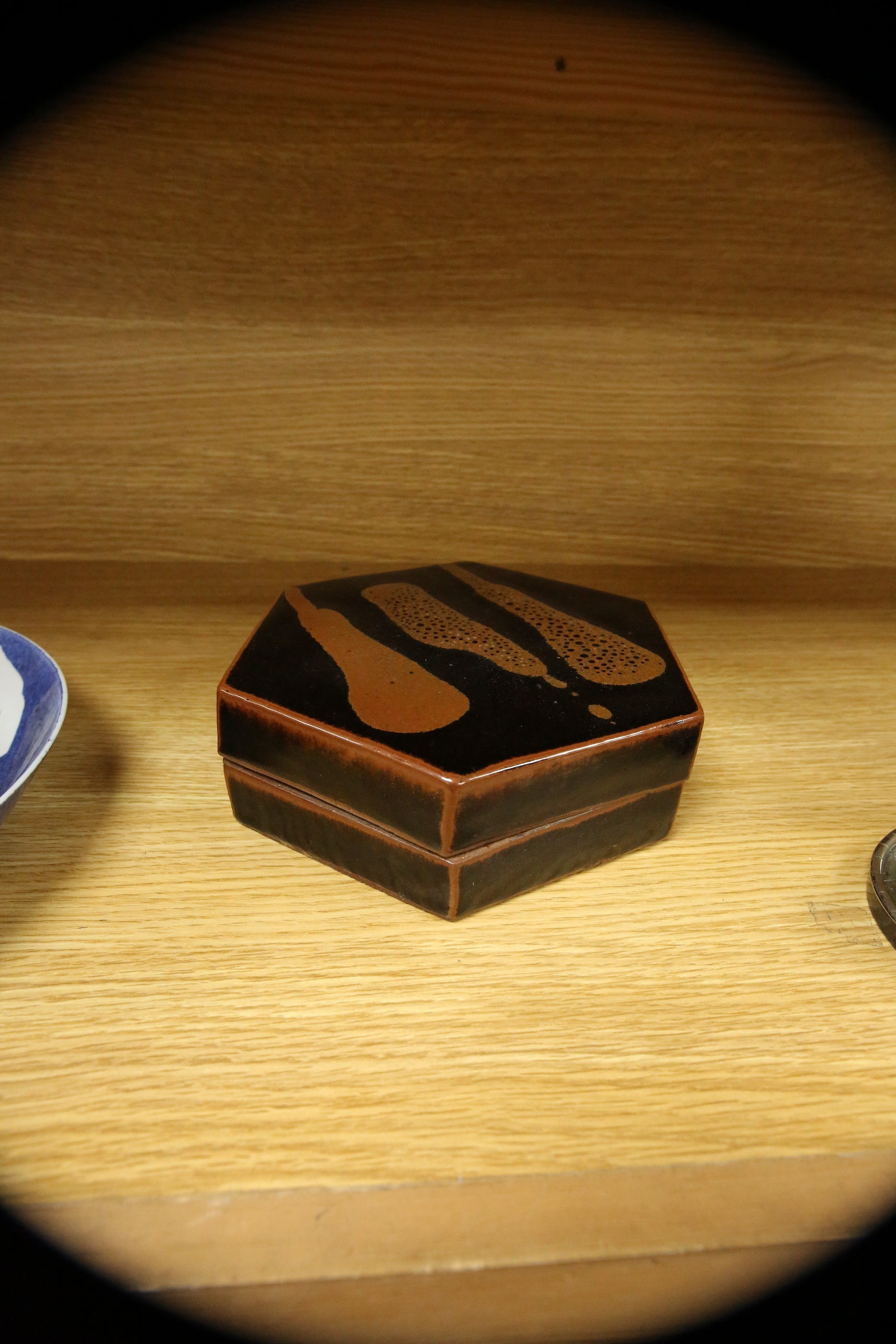 A Japanese studio tenmoku glazed hexagonal box and cover, unmarked, 18cm wide. Condition - good